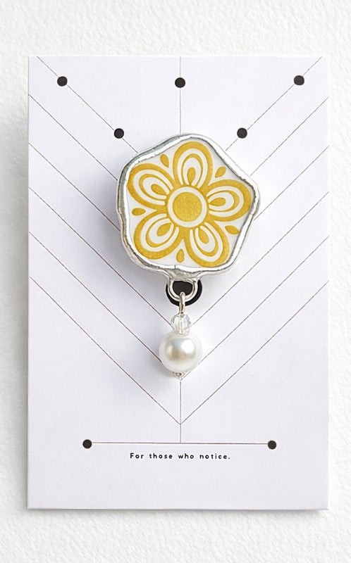 Floral design clip with pearl on a white card